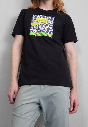 T-shirt noir à manches courtes avec un graphique coloré comportant un imprimé animal et un texte en gras. Matériau doux avec une coupe décontractée.