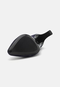 Navy suede high heel with a triangular black patent leather sole. Features a curved back and smooth texture.