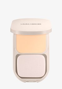 Pudro compatto con un'esterno beige, che presenta una porzione di polvere colorata sopra e una spugnetta applicatrice bianca sotto.
