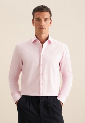 Lichtroze langemouw shirt met een klassieke kraag, knopen aan de voorkant en een gladde stofstructuur, gecombineerd met donkere broeken.