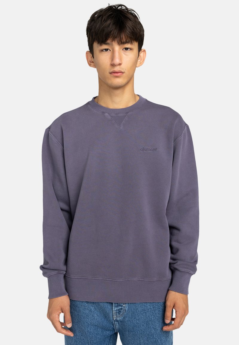 Purple sweatshirt with ribbed crewneck, dropped shoulders, and elastic cuffs. Features a subtle logo on the chest and smooth texture.