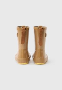 Egy pár fényes barna gumicsizma sárga talppal és bőr húzófüllel, amelyeken a "bisgaard" felirat olvasható, hátulnézetből, fehér háttéren.