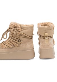 Botine bej până la glezne, cu un design pufos texturat, căptușeală din blană sintetică și o talpă chunky cu vârf rotund și șireturi.