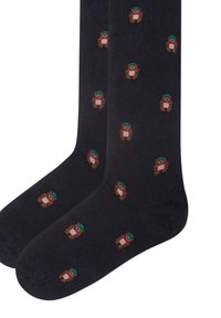 Navy Socken aus weichem Stoff mit einem sich wiederholenden Muster von kleinen braunen Bären, die grüne Hüte und rote Schals tragen.