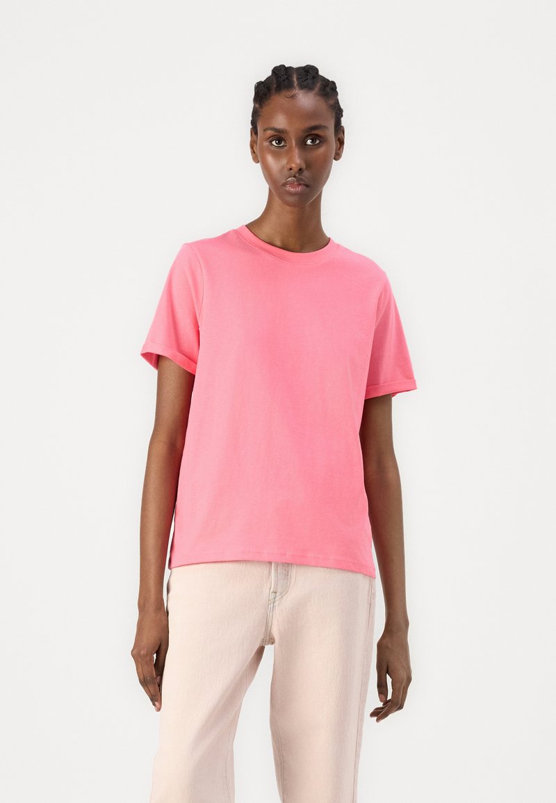 Roze katoenen t-shirt met een ronde hals en korte mouwen. Heeft een losse pasvorm en zijsplitten voor bewegingsgemak.