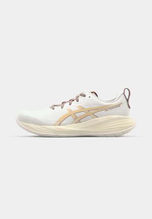 Running shoe in white with light orange accents. Features a smooth fabric upper, cushioned sole, and lacing system with brown laces.