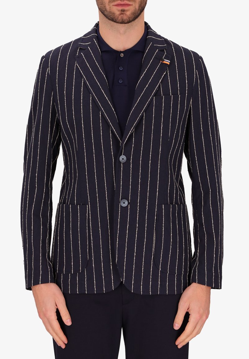 Blazer a righe navy con righe bianche, due tasche frontali, rever a scottatura, due bottoni e taschino a toppa sul lato sinistro del petto. Tessuto misto cotone.