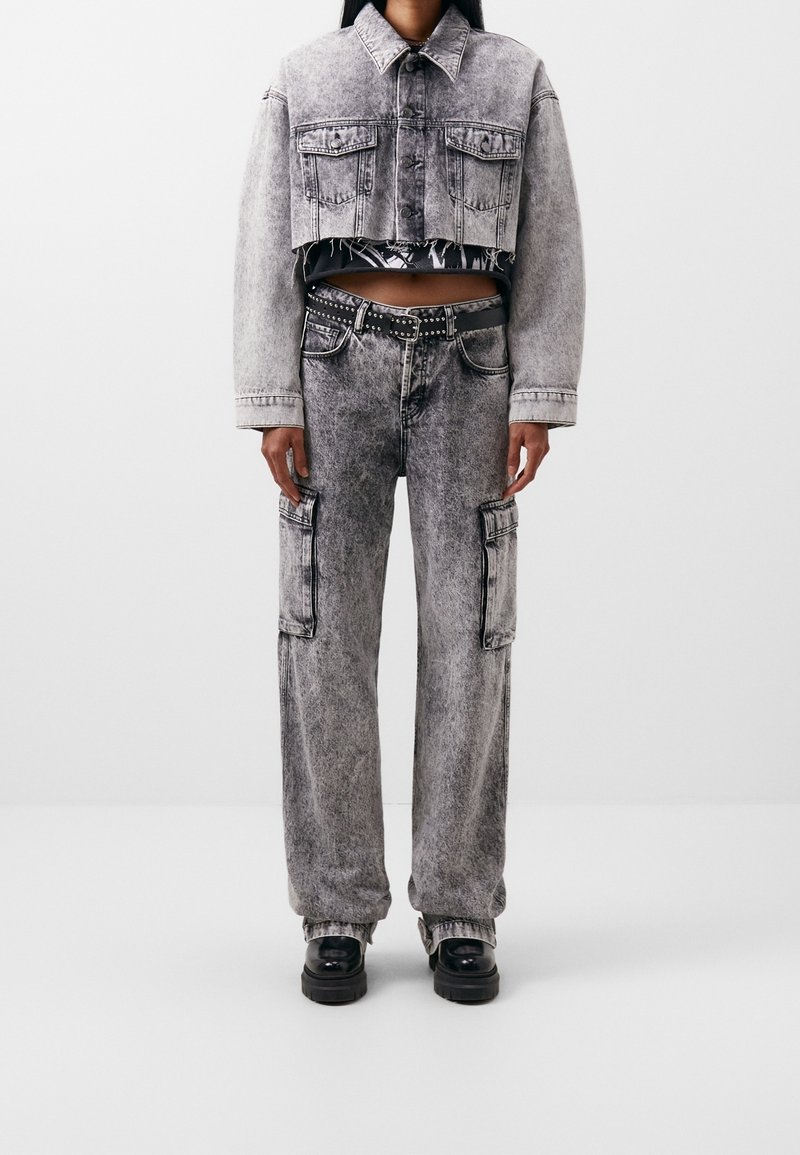 Lyhyet farkkutakki ja viittahousut haalistuneessa mustassa, jossa on teksturoidun näköinen pinta. Takissa on kaksi etutaskua; housuissa on sivutaskut.