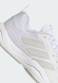 Weißer Sportschuh mit strukturiertem Mesh-Obermaterial, Gummisohle und drei weißen Streifenakzenten; verfügt über ein verstellbares Schnürsystem.