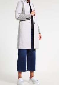 Wollmischungsjacke in Hellgrau mit dunkleren Grautönen, taillierte Passform, einreihiges Design und Knopfdetails an den Ärmeln.