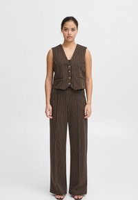 Gilet rayé marron avec un col en V plongeant, six boutons dorés et deux poches avant, assorti à un pantalon évasé. Texture lisse.