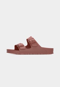 Σκούρο ροζ σανδάλι τύπου slip-on με δύο ρυθμιζόμενα λουράκια με αγκράφες και υφασμένη σόλα, εμφανίζεται από το πλάι πάνω σε μονόχρωμο φόντο.