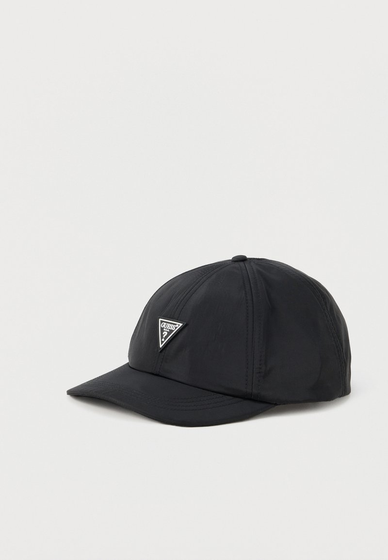 Casquette de baseball noire avec des panneaux cousus et un logo triangulaire Guess à l'avant sur un fond clair uni.