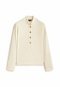 Top a maniche lunghe color crema con colletto alto e cinque bottoni decorativi dorati lungo la pattina anteriore.