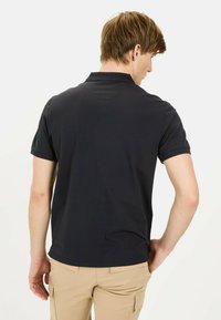 Navy polo shirt met korte mouwen en een klassieke kraag. Soepele textuur, minimalistisch ontwerp zonder zichtbare logo's of patronen.
