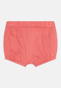 Shorts de couleur corail avec une taille élastique, texture froncée et ourlet arrondi. Tissu léger avec un effet froissé doux.
