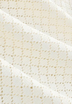 Bela teksturirana tkanina z motivom cvetja in izbočenimi poudarki. Vzorec vključuje izmenjujoča se tkana in gladka območja.