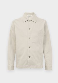 Light beige shirt jacket made of cotton, featuring a collared neckline, front button closure, single chest pocket, and long sleeves.