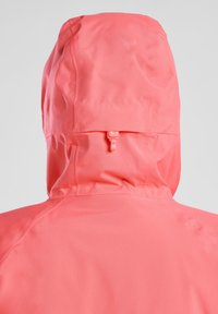 Giacca cappuccio corallo con texture liscia, dotata di collo arricciato e un fermacorda in plastica, che mette in risalto un design minimalista.