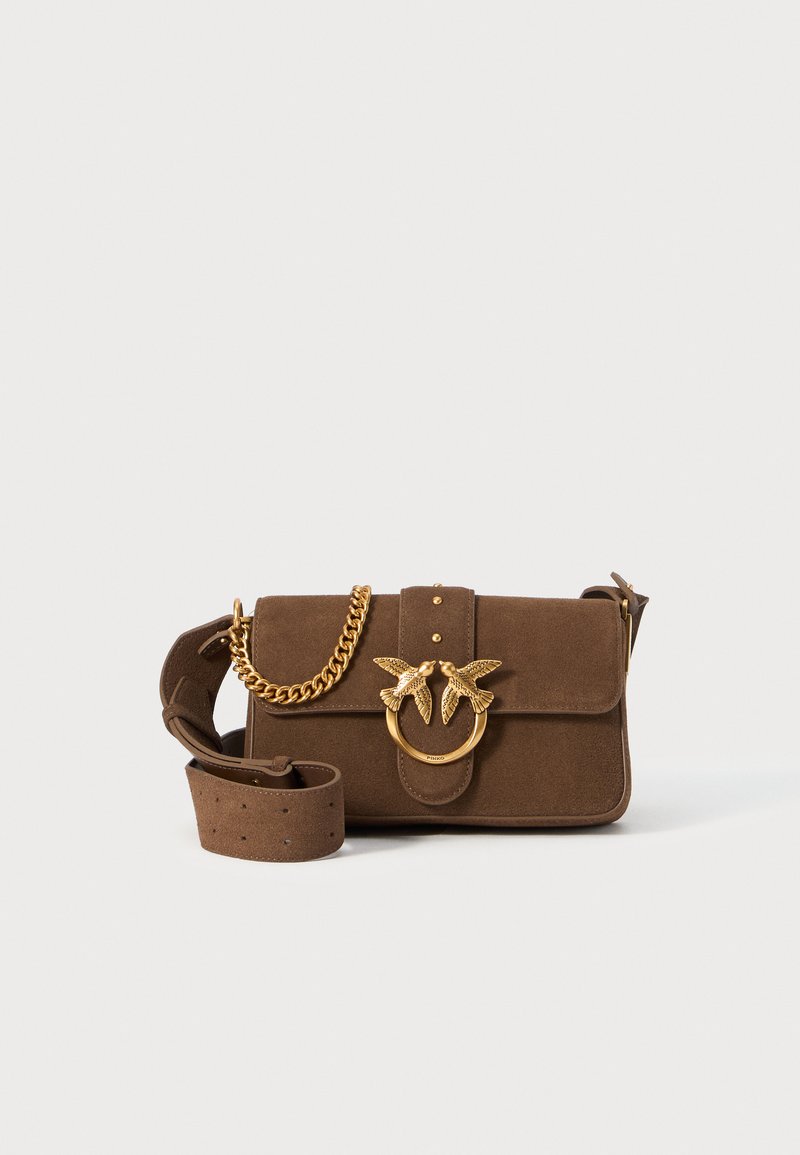 Brūns zamšādas rokassomiņš ar plurālo slēgšanu, zelta toņos ķēde un putnu motīva furnitūra, regulējama siksna ar perforācijām, strukturēts dizains.