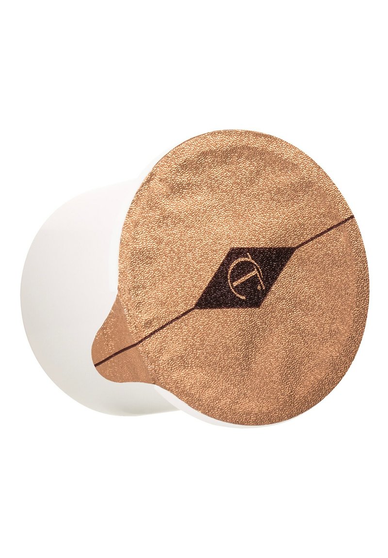 White container with a textured copper lid. Lid features a dark diamond shape and a stylized logo in the center. Smooth surface.