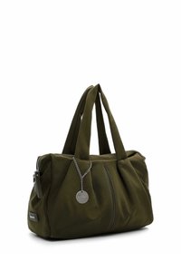 Sac à main en tissu doux vert foncé avec deux poignées, fermeture éclair et une petite étiquette ronde en métal suspendue à une chaîne.