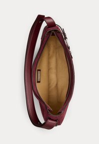 Borsa a mano in pelle borgogna con esterno liscio, chiusura con zip e interno in tessuto beige. Dotata di una lunga tracolla regolabile.