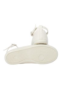 Sandalo in tessuto bianco con suola texturizzata, cinturino alla caviglia regolabile e design minimalista con finitura liscia e cuciture sottili.
