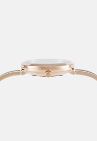 Goldfarbener Analoguhren mit schlankem Profil, rundem Gehäuse, glattem Lünette und einer Krone an der Seite. Das Armband ist aus Metall mit glänzender Oberfläche.