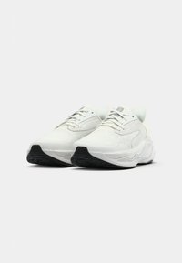 Hvide sneakers med tekstureret overdel, snørebåndslukning og sort gummisål. Rundet design med polstret mellemsål og minimal branding.