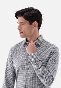 Grau-weißer Gingham-Karo-Hemd mit Kragen, langen Ärmeln und glatter Textur, ausgestattet mit Knopfmanschetten und einem taillierten Schnitt.