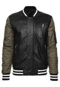 Blouson aviateur en cuir noir avec manches en nylon vert olive, poignets et ourlet côtelés rayés blanc et noir, doté de poches à fermeture éclair et à boutons-pression.