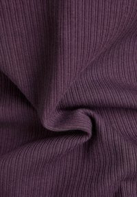 Lila ribbat tyg med en mjuk textur, som visar subtila horisontella linjer och en slät yta, tvinnad för att visa djup och dimension.