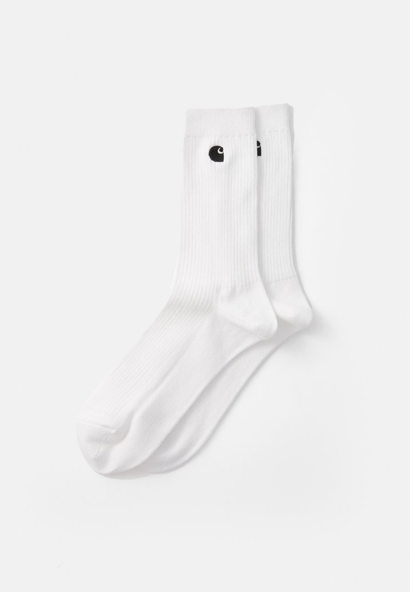 Chaussettes blanches côtelées avec un design de logo noir près du haut. Fabriquées en matériau doux et présentant une longueur mi-mollet avec un renfort au niveau des orteils et du talon.