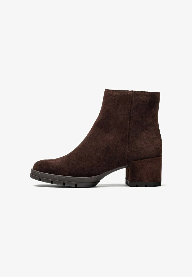 Stivali alla caviglia in suede marrone con tacco spesso, caratterizzati da una texture liscia e una punta arrotondata, progettati per comfort e supporto.