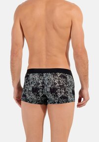 Schwarze Boxershorts mit mehrfarbigem Tiermotiv-Design, ausgestattet mit einem elastischen Bund und glatter Stofftextur.