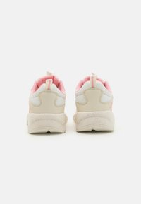 Beige sneakers med ljusrosa detaljer, texturerat meshnät och syntetiska material, rundad form och prickiga sulor. Bakre dragflik inkluderas.