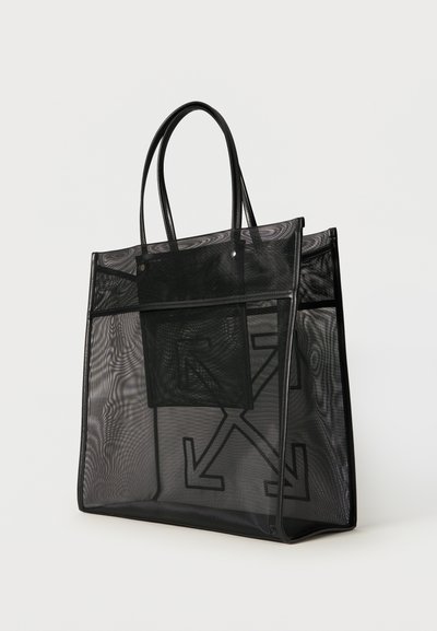 Μαύρη διαφανής τσάντα ώμου με μακριά χερούλια και εσωτερική θήκη, με μεγάλο σχέδιο βέλους ορατό μέσα από το υλικό από δίχτυ.