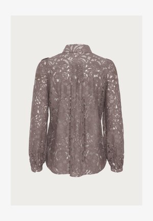 Spetsblus i mauve med blommönster, lång ärm och krage. Bakdelen har knäppning och en något lös passform.