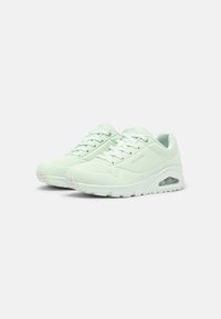 Mintgröna sneakers med en slät syntetisk ovandel, perforerade detaljer och en vadderad sula med en synlig luftkammare.