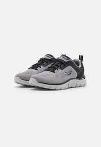 Lightweight athletic shoes in grey mesh with black accents. Features a flexible sole, lace-up design, and pull tab at the heel.