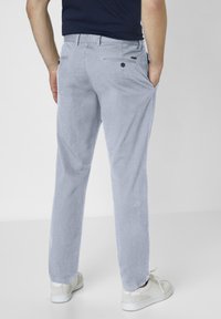 Light blue corduroy pants with a straight-leg design, featuring back pockets, subtle texture, and paired with white sneakers.