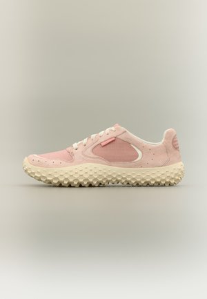 Világos rózsaszín alacsony szárú sportcipő fehér fűzőkkel és vastag, texturált törtfehér talppal, oldalnézetben, semleges háttéren.