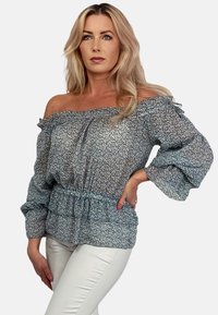 Bluzka odsłonięta na ramionach w jasnoniebieskim kolorze, z kwiatowym wzorem, bufkami i dopasowaną talią. Wykonana z lekkiego, teksturowanego materiału.