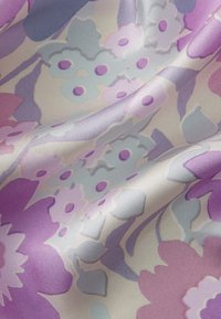 Silk fabric featuring a floral pattern in shades of lavender, blue, and cream, with smooth texture and subtle sheen.
