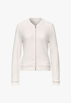 Valkoinen, teksturoidulla pinnalla varustettu pitkähiha jacketti, jossa on koko frontin täyttävä vetoketju, resorireunaiset hihansuut ja pyöreä kaulus, esitetty yksivärisellä taustalla.