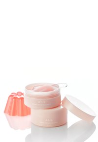 Pots d'implants oculaires Abib PDRN de couleur rose pâle, avec un couvercle transparent et une spatule. Un moule en gelée de la même teinte rose est placé à côté des pots.