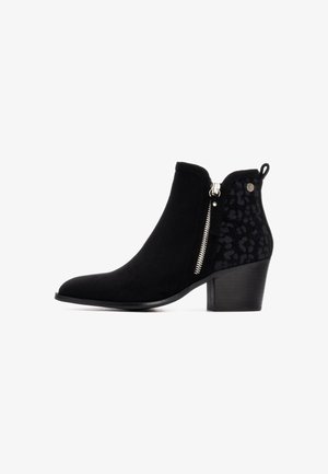 Bota negra hasta el tobillo con punta afilada, hecha de ante y con un panel de tela con estampado de leopardo, cremallera lateral y un tacón bloque medio.