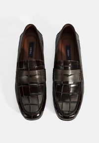 Dunkelbraune Lederloafer mit strukturiertem Krokodilmuster, im Schlupfdesign und einem glatten Akzentband über der Oberseite.
