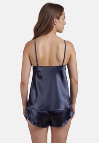 Navy Satin-Camisole und Shorts-Set mit verstellbaren Trägern, glatter Textur und schwingendem Saumdetail an den Shorts.
